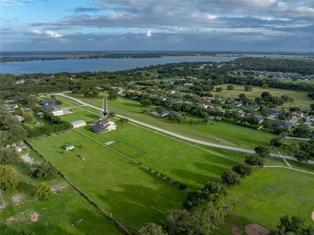 a room with lots of white furniture and wooden floor