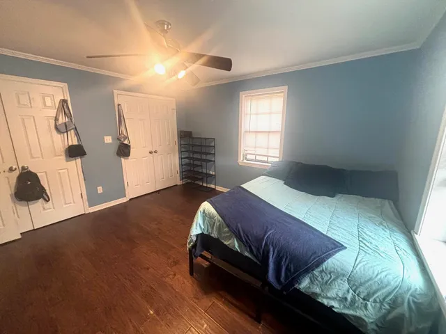 a bedroom with a bed and wooden floor