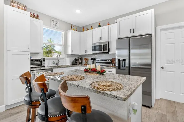 a kitchen with kitchen island a appliances dining table and chairs