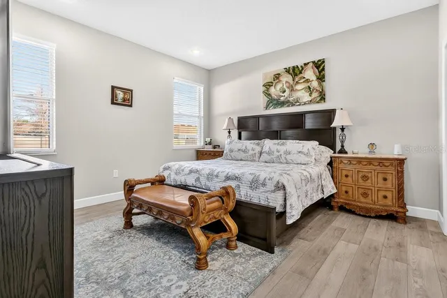 a bedroom with a bed and wooden floor