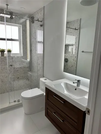 a bathroom with a sink toilet and shower