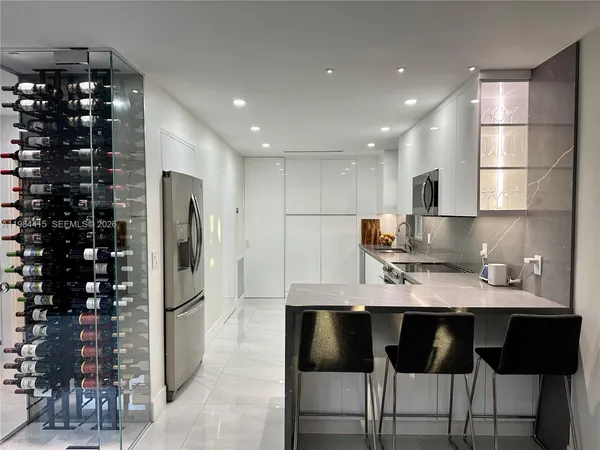 a kitchen with granite countertop a refrigerator a stove a dining table and chairs
