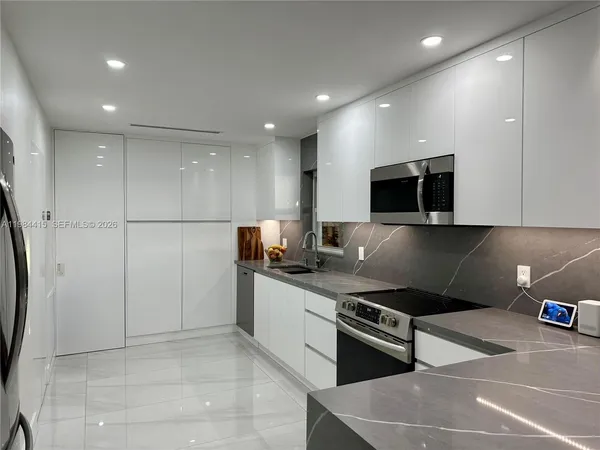 a kitchen with stainless steel appliances granite countertop a refrigerator and a stove top oven