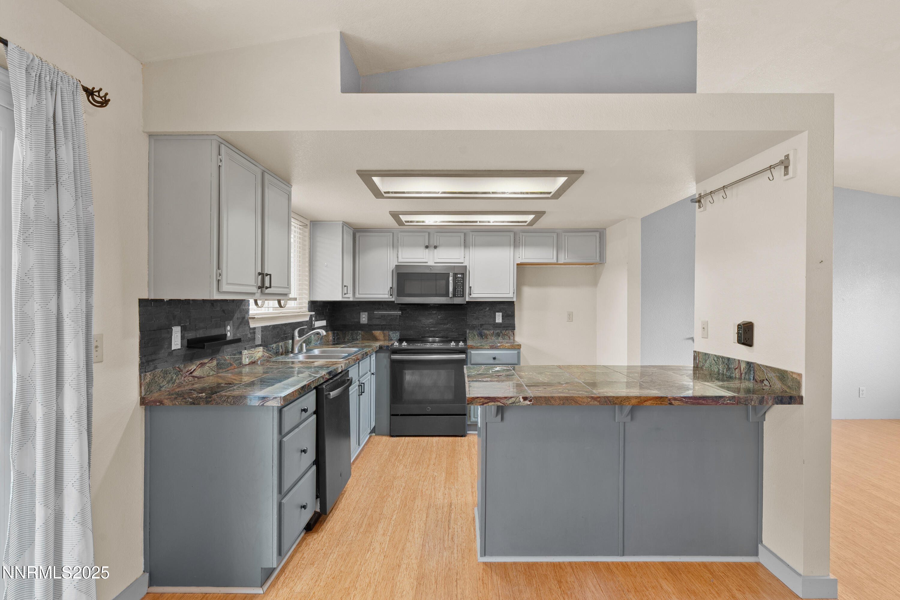 997 Ridgeview Drive Carson City, NV 89705 - Photo 11 of 32 a kitchen with stainless steel appliances granite countertop a stove a sink and a refrigerator