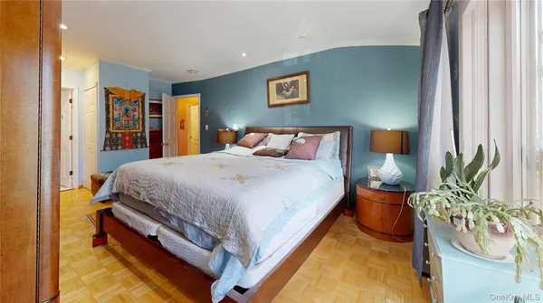 a bed sitting in a spacious bedroom next to a window
