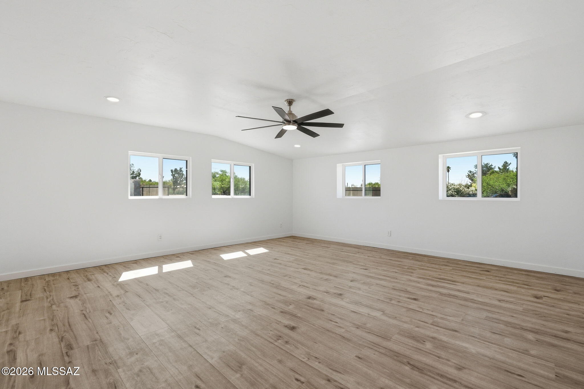 950 West Ina Road Tucson, AZ 85704 - Photo 17 of 54 an empty room with wooden floor fan and windows