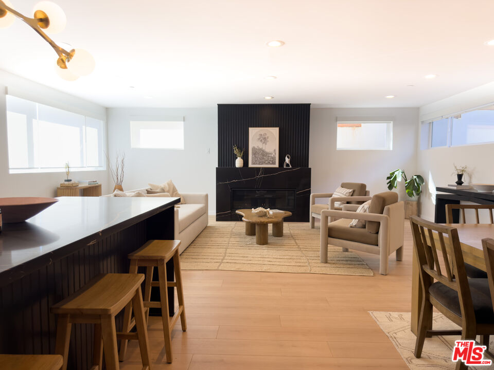 a living room with furniture a table and kitchen view