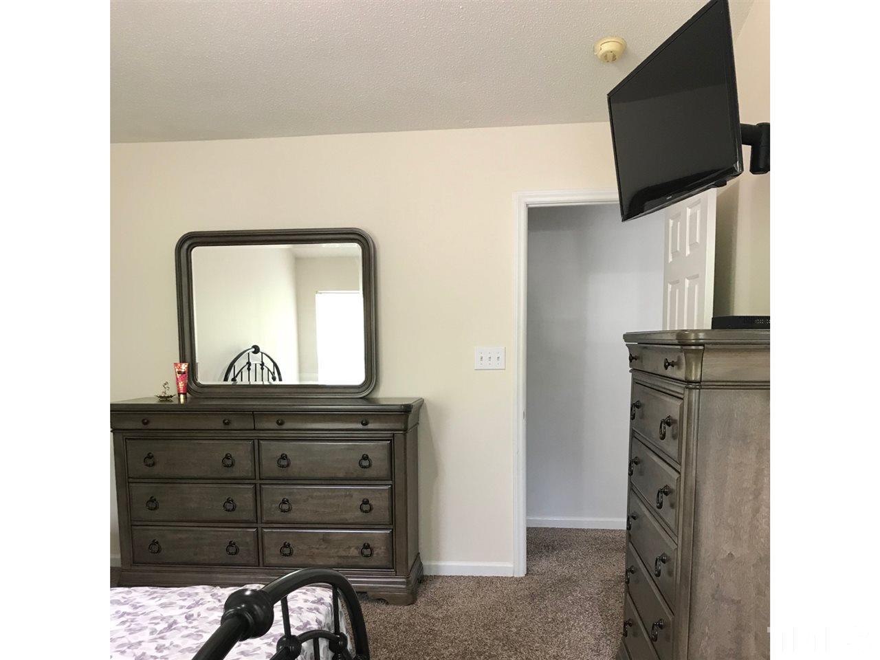 8612 Neuse Hunter Drive Raleigh, NC 27616 - Photo 15 of 23 a close view of a dresser and a mirror in a room
