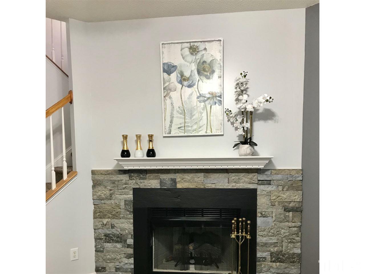 8612 Neuse Hunter Drive Raleigh, NC 27616 - Photo 5 of 23 a living room with a fireplace and chandelier
