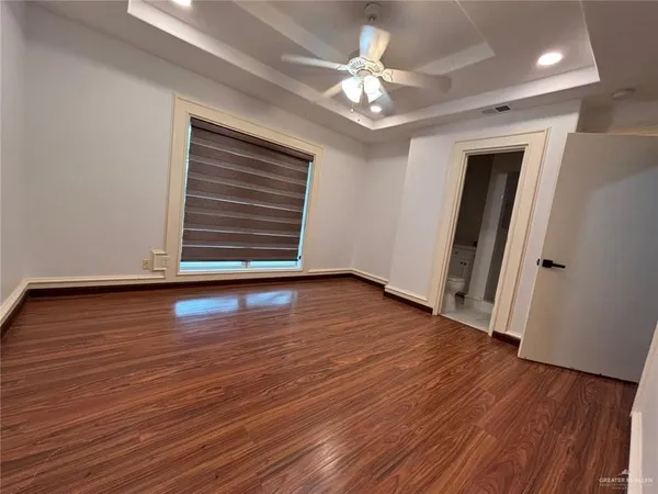 an empty room with wooden floor and window