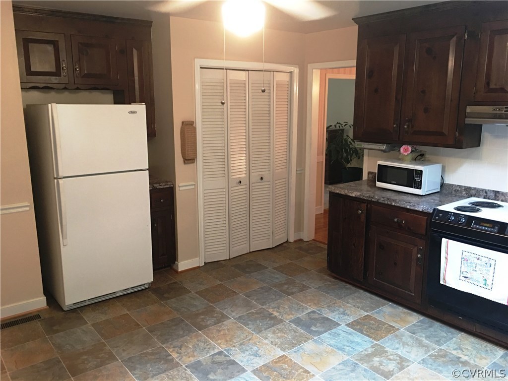 11420 Chalkley Road Chester, VA 23831 - Photo 6 of 43 a view of a kitchen with a refrigerator a stove top oven and cabinets