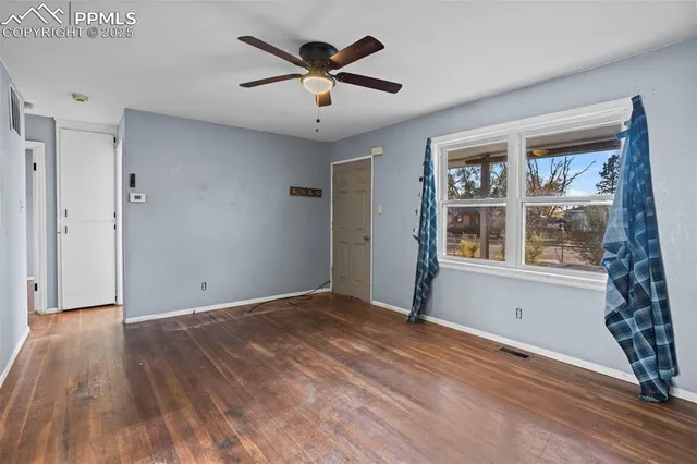 wooden floor in an empty room with a window