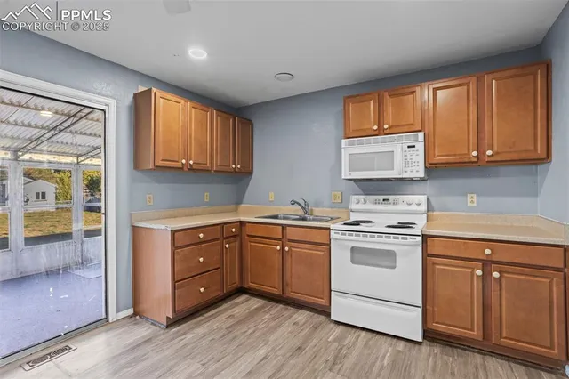 a kitchen with white cabinets sink and appliances