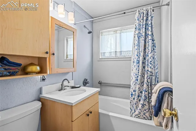 a bathroom with a sink a toilet and shower curtain