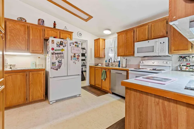 a kitchen with a refrigerator a stove top oven a sink and cabinets