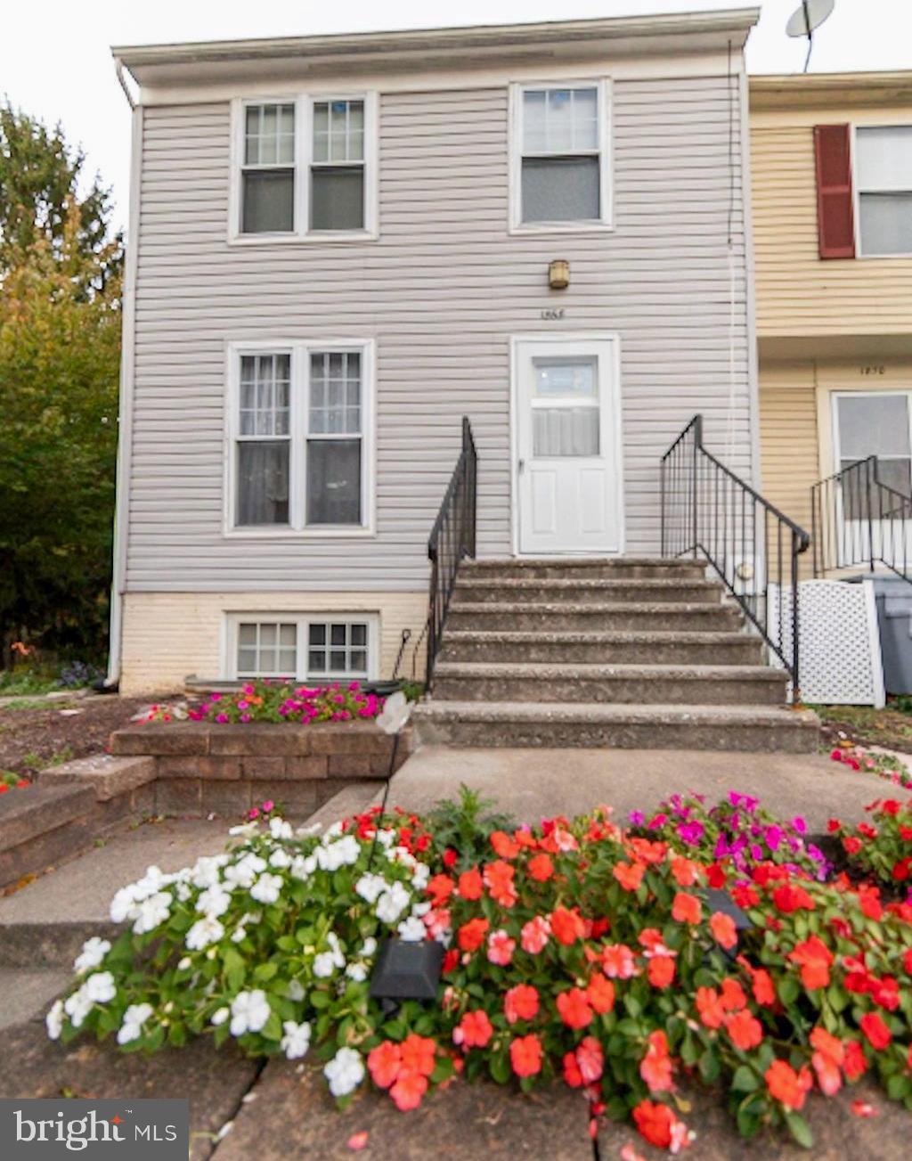 a front view of a house with lots of flowers