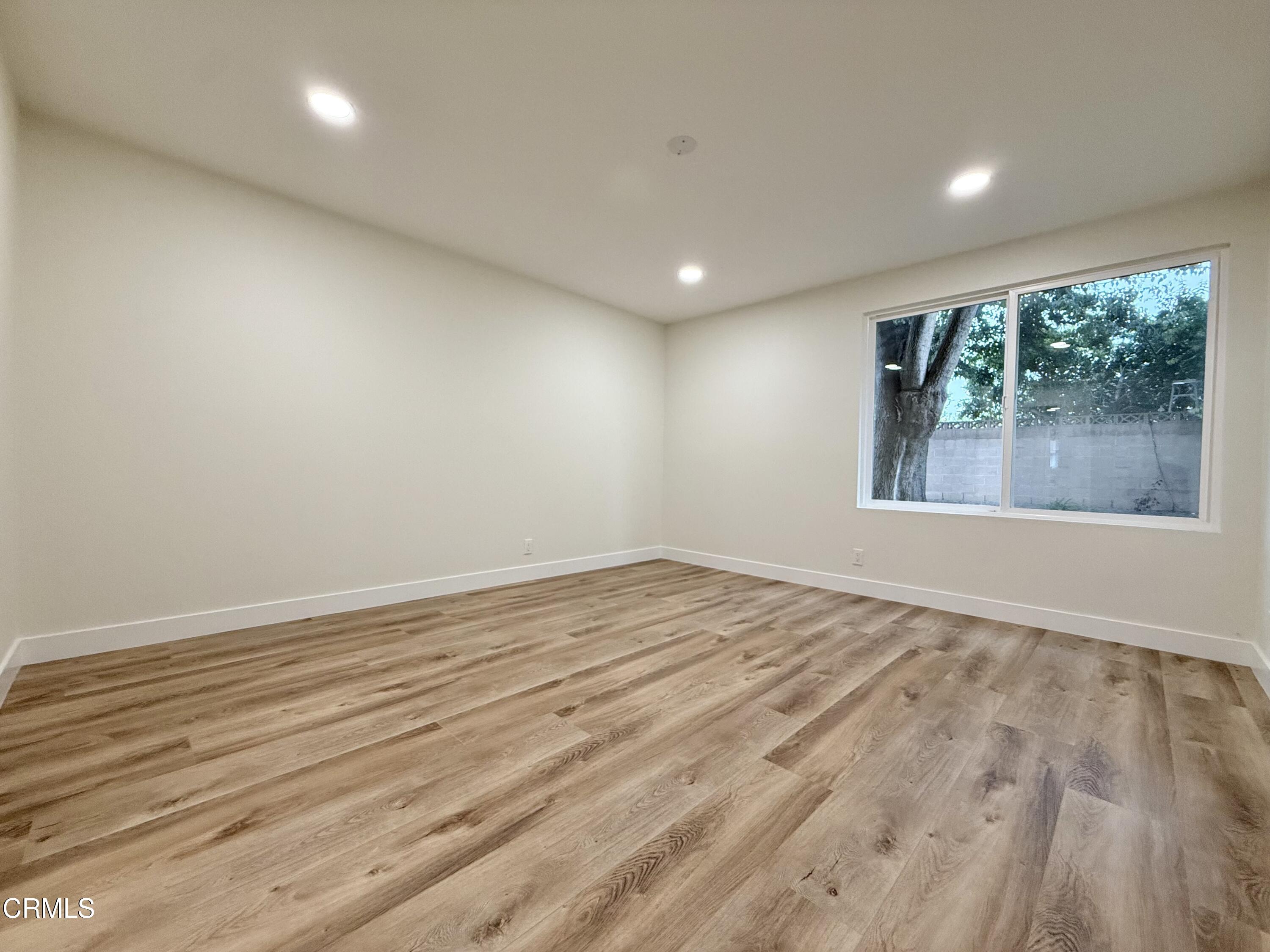 2124 Pamela Street Oxnard, CA 93036 - Photo 12 of 23 an empty room with wooden floor and windows