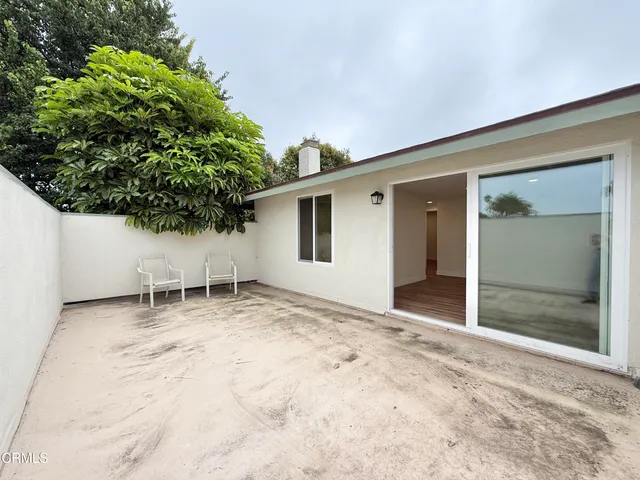 a view of an empty room with potted plants and wooden bench