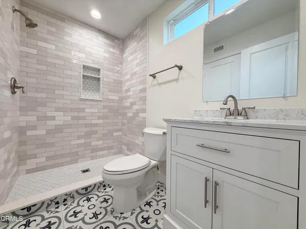 a bathroom with a sink toilet vanity and shower