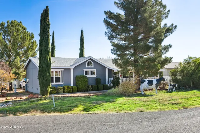 a front view of a house with a yard and potted plants