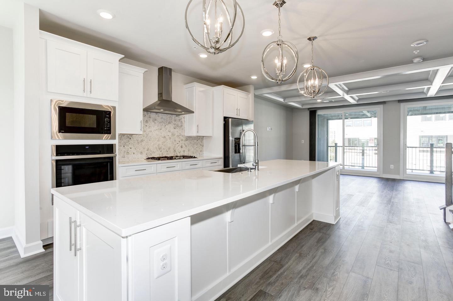 a large kitchen with stainless steel appliances a large counter space a stove and cabinets