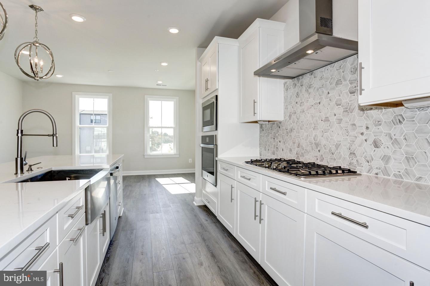 12923 Sunrise Ridge Alley Herndon, VA 20171 - Photo 3 of 25 a kitchen with granite countertop a stove sink and cabinets