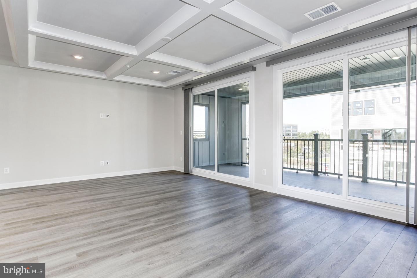 12923 Sunrise Ridge Alley Herndon, VA 20171 - Photo 7 of 25 a view of an empty room with wooden floor and a window
