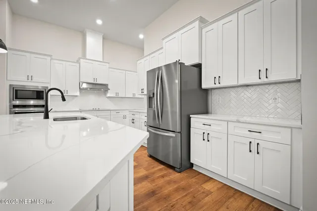 a kitchen with stainless steel appliances a refrigerator sink and cabinets