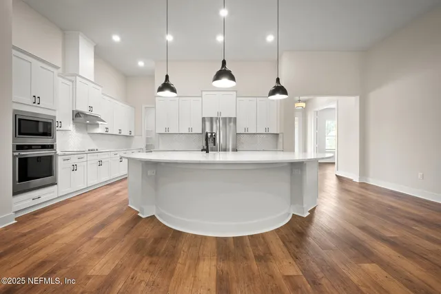 a large kitchen with stainless steel appliances kitchen island a large island in the center