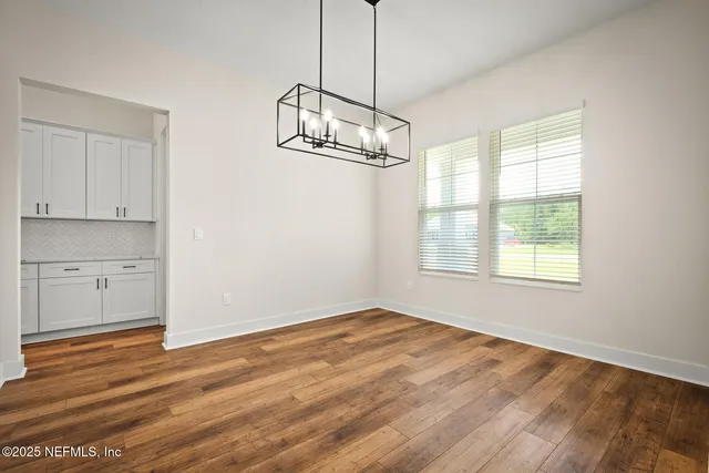 a view of empty room with wooden floor and window
