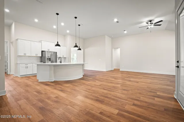 a view of a kitchen with kitchen island a sink stainless steel appliances and cabinets