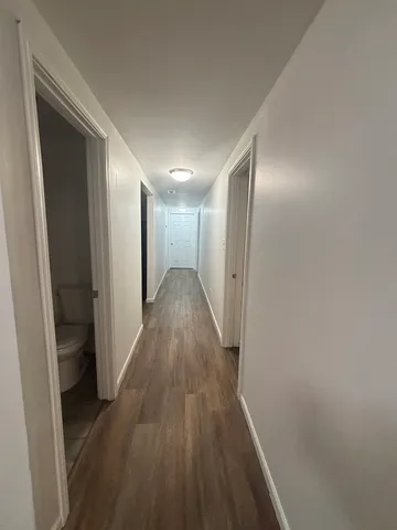 a view of hallway with wooden floor