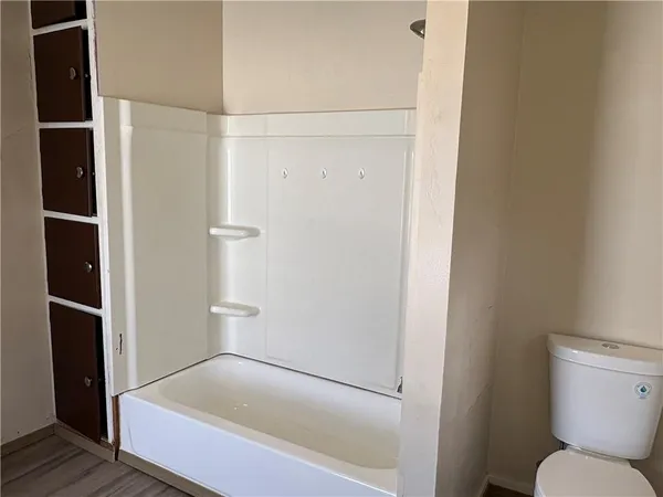 a bathroom with a tub and toilet