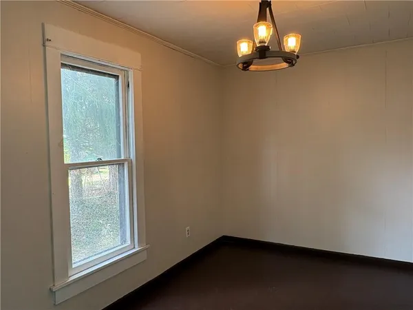 an empty room with wooden floor mirror and windows