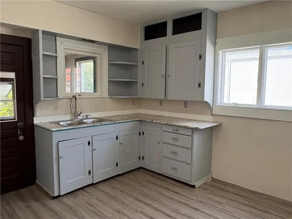 a bathroom with a granite countertop sink mirror and cabinets