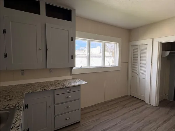an empty room with wooden floor and window