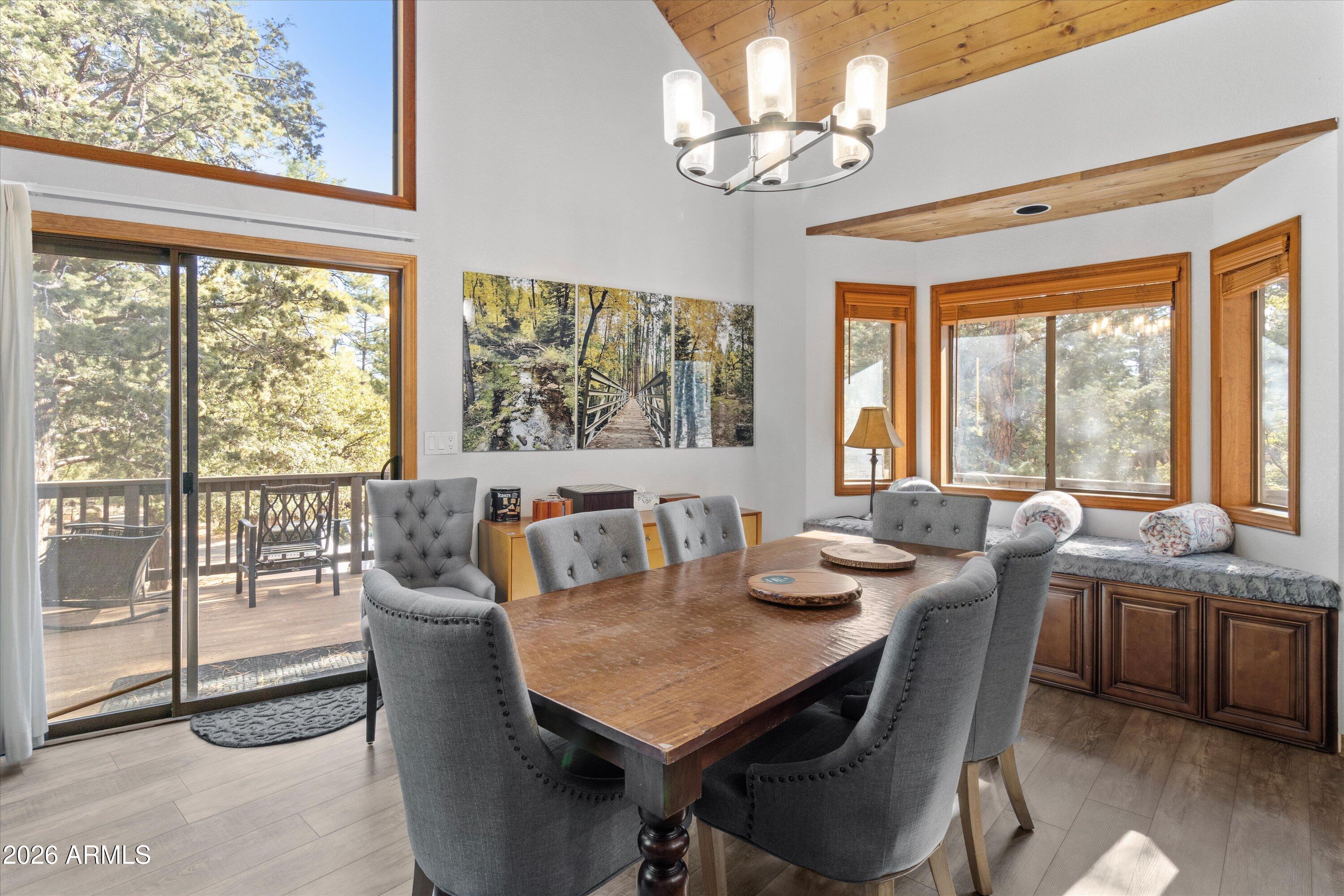 6181 Pinon Loop Pine, AZ 85544 - Photo 7 of 36 a view of a dining room with furniture large windows and wooden floor