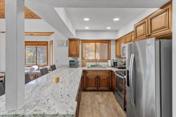 a large kitchen with stainless steel appliances granite countertop a lot of counter space and a refrigerator