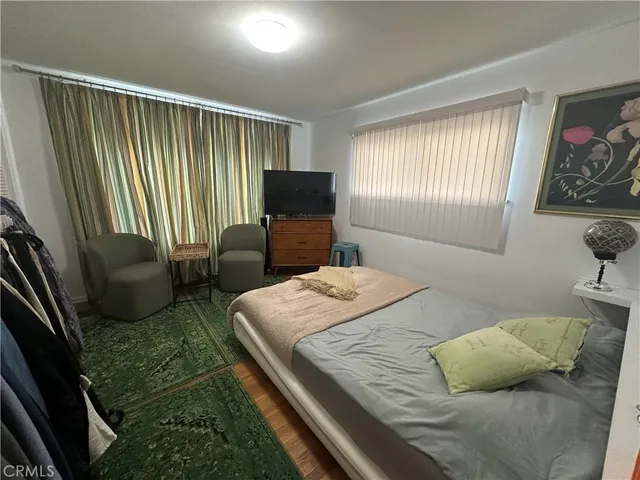a bedroom with a bed couch and a large window