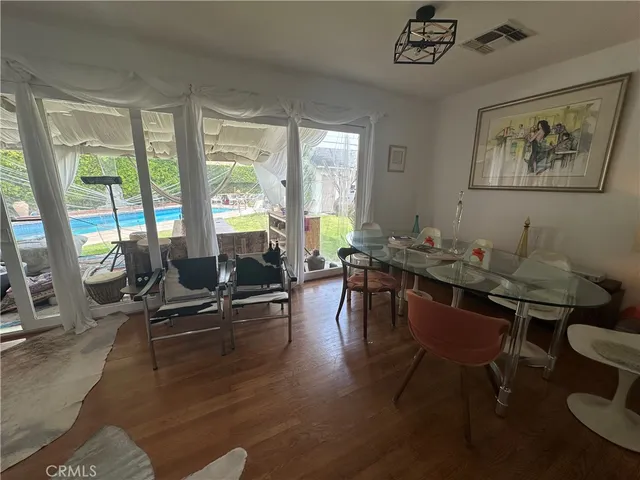 a living room with furniture a large window and dining table