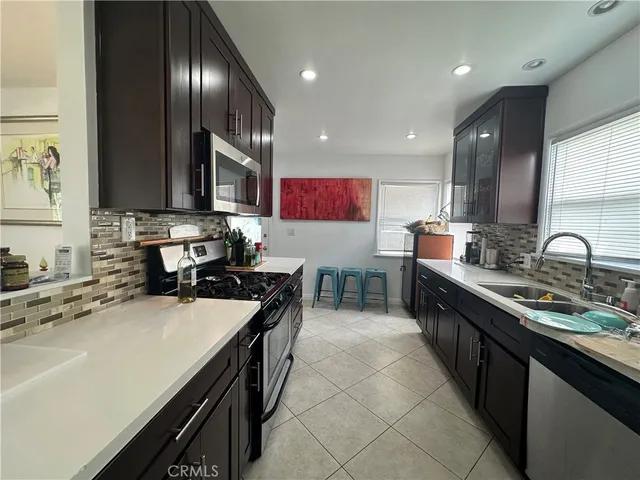 a kitchen with stainless steel appliances a sink stove and cabinets