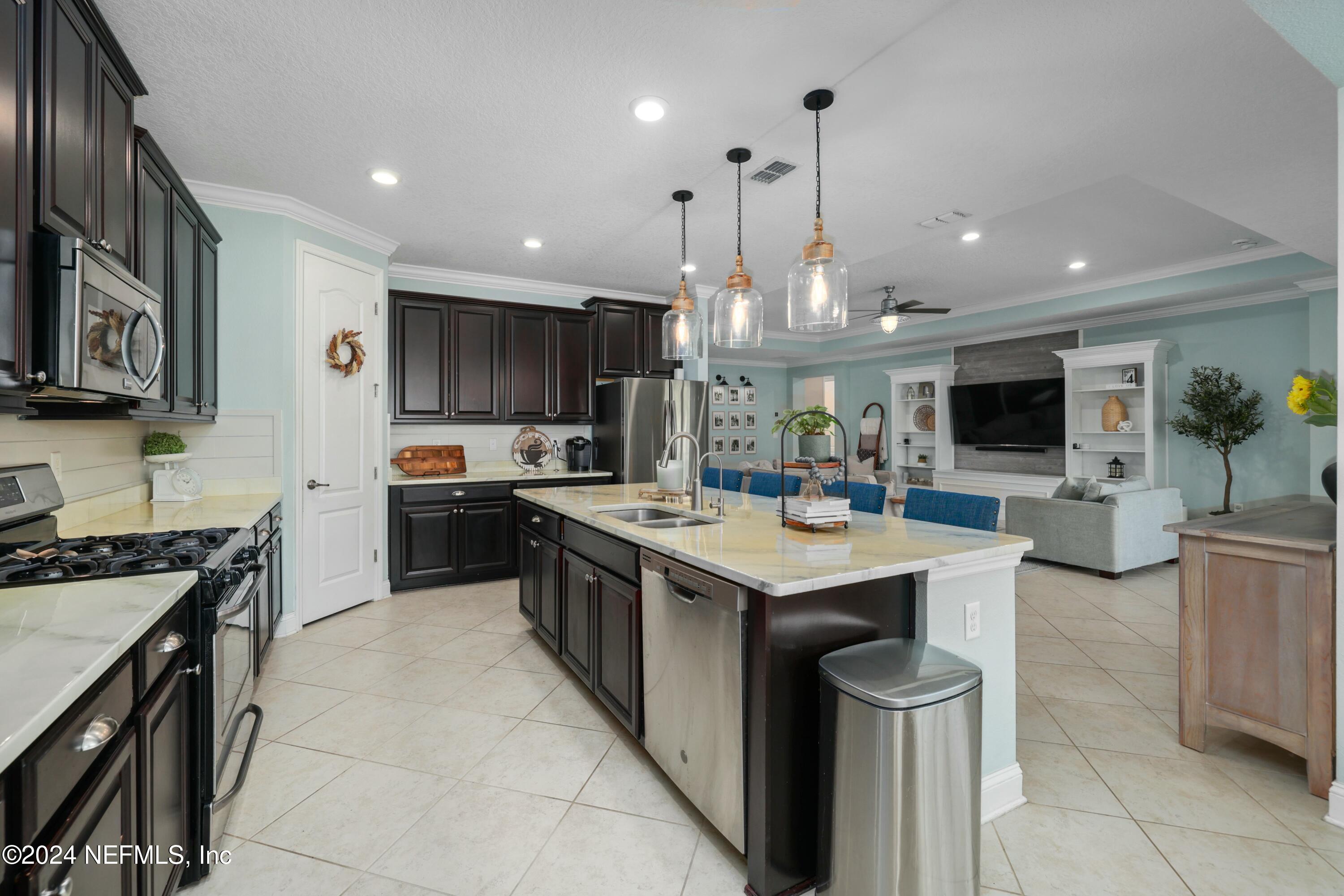 404 St Kitts Loop St. Augustine, FL 32092 - Photo 11 of 68 a kitchen with stainless steel appliances granite countertop a sink stove and refrigerator