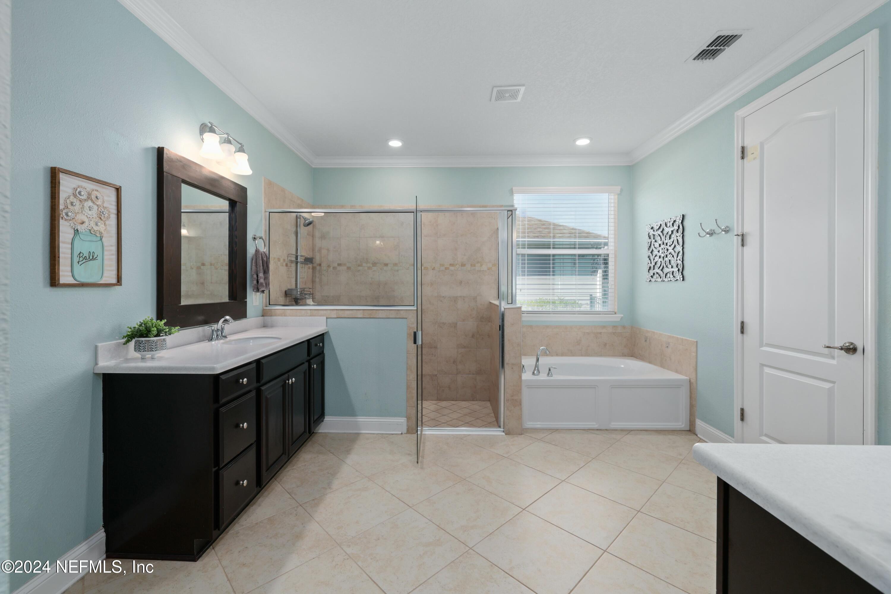 404 St Kitts Loop St. Augustine, FL 32092 - Photo 21 of 68 a bathroom with a double vanity sink a large mirror and a bathtub