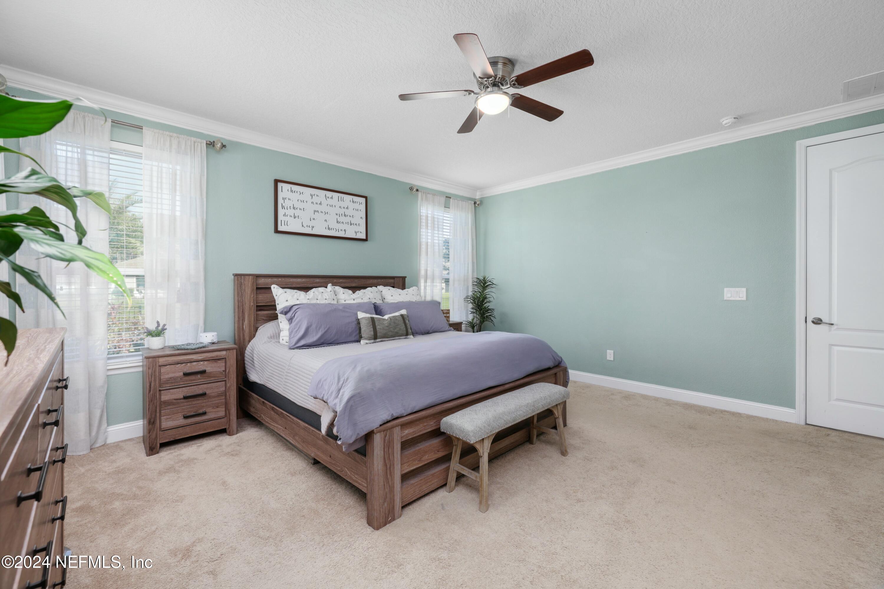404 St Kitts Loop St. Augustine, FL 32092 - Photo 59 of 68 a spacious bedroom with a bed and a chandelier