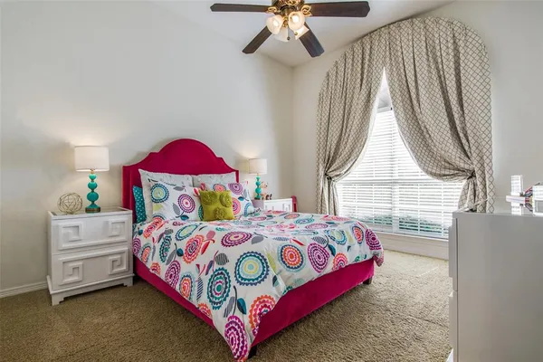 a bedroom with a bed a dresser and a window