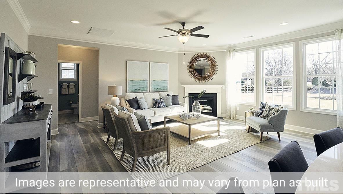 5037 Chase Hill Way Raleigh, NC 27603 - Photo 10 of 41 a living room with furniture a large window and a fireplace