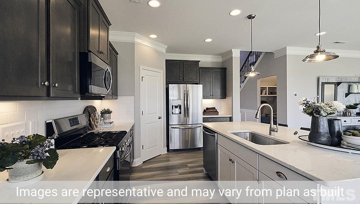 5037 Chase Hill Way Raleigh, NC 27603 - Photo 12 of 41 a kitchen with stainless steel appliances kitchen island granite countertop a refrigerator a sink a stove and cabinets