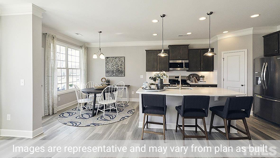 5037 Chase Hill Way Raleigh, NC 27603 - Photo 13 of 41 a dining room with stainless steel appliances kitchen island granite countertop a dining table chairs and view living room