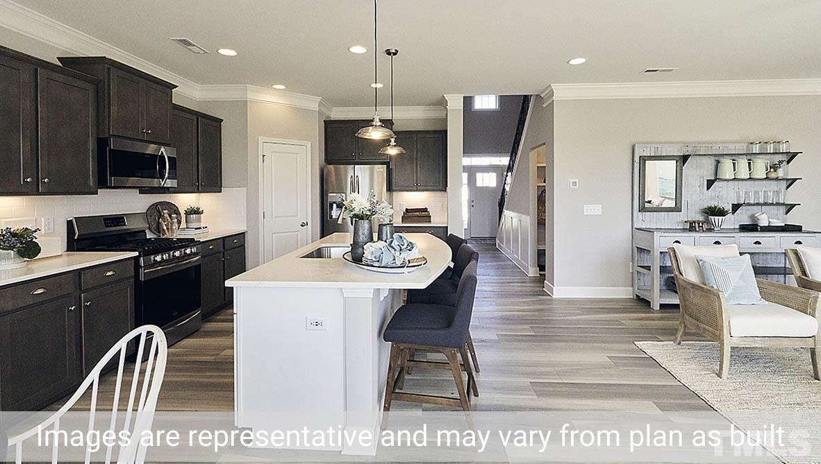5037 Chase Hill Way Raleigh, NC 27603 - Photo 16 of 41 a kitchen with stainless steel appliances kitchen island granite countertop a refrigerator a stove a microwave oven a sink a dining table and chairs with wooden floor