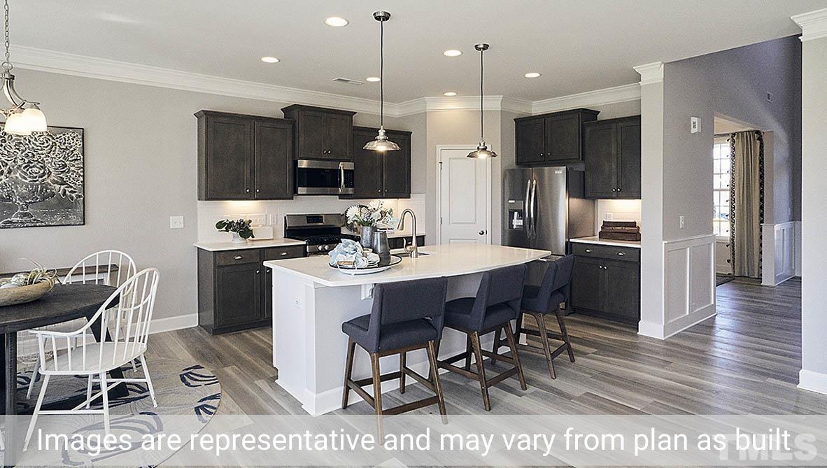 5037 Chase Hill Way Raleigh, NC 27603 - Photo 18 of 41 a kitchen with stainless steel appliances kitchen island granite countertop a table chairs and a refrigerator